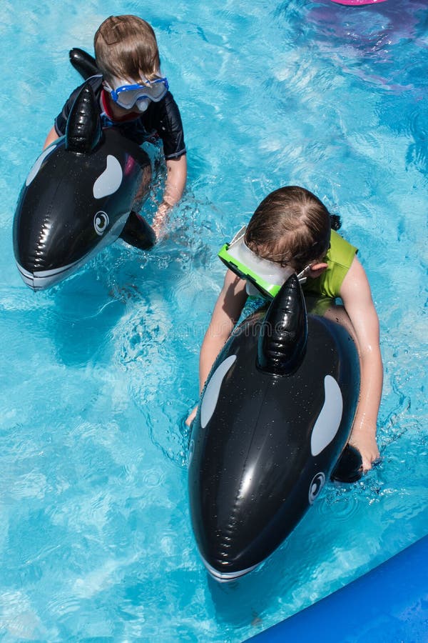 Twee jongens die vlotters in binnenplaatspool berijden royalty-vrije stock afbeelding Twee jongens die vlotters in binnenplaatspool berijden royalty-vrije stock afbeelding