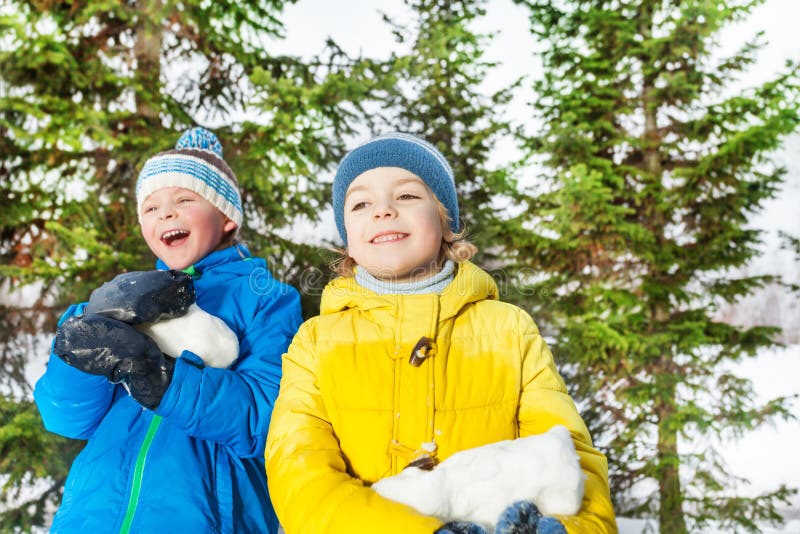 Twee jongens met grote brok van sneeuw in het park royalty-vrije stock afbeelding Twee jongens met grote brok van sneeuw in het park royalty-vrije stock afbeelding