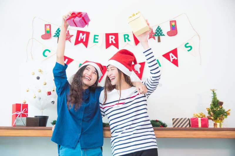 Twee meisjes die giftdozen en glimlach in Kerstmispartij thuis houden royalty-vrije stock afbeelding Twee meisjes die giftdozen en glimlach in Kerstmispartij thuis houden royalty-vrije stock afbeelding