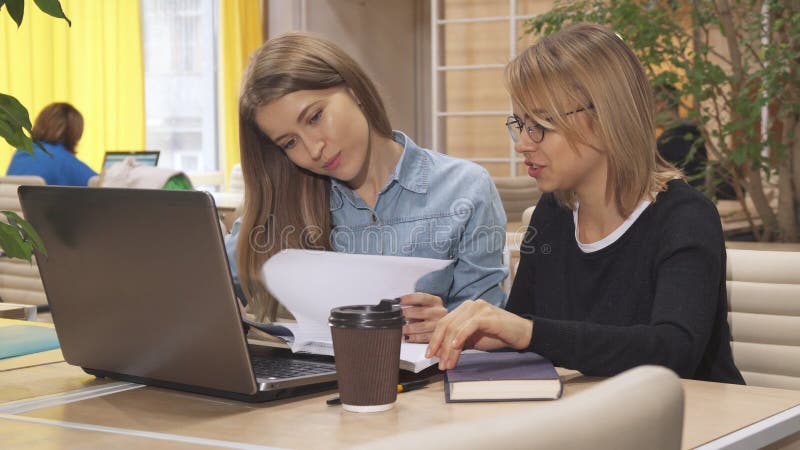 Twee meisjes doorbladeren één of ander dagboek bij de werkende hub stock afbeeldingen Twee meisjes doorbladeren één of ander dagboek bij de werkende hub stock afbeeldingen