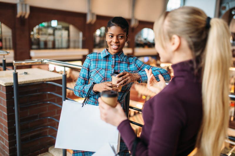 Twee meisjes drinkt koffie na het winkelen stock afbeelding Twee meisjes drinkt koffie na het winkelen stock afbeelding