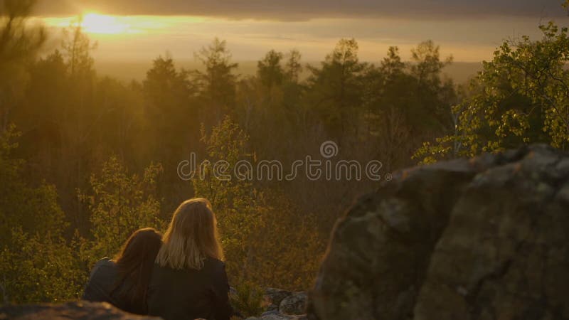 Twee meisjes kijken op de zonsondergang