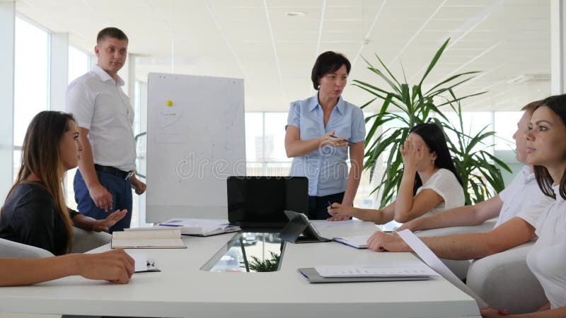 Twee mensen dichtbij flipchart bieden ideeën dichtbij bedrijfsmensen aan luisteren presentatie