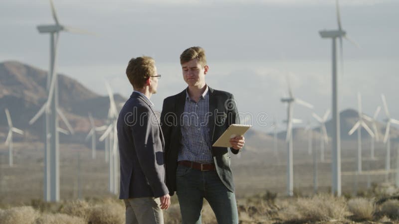 Twee mensen die een overeenkomst maken dichtbij de windmolens