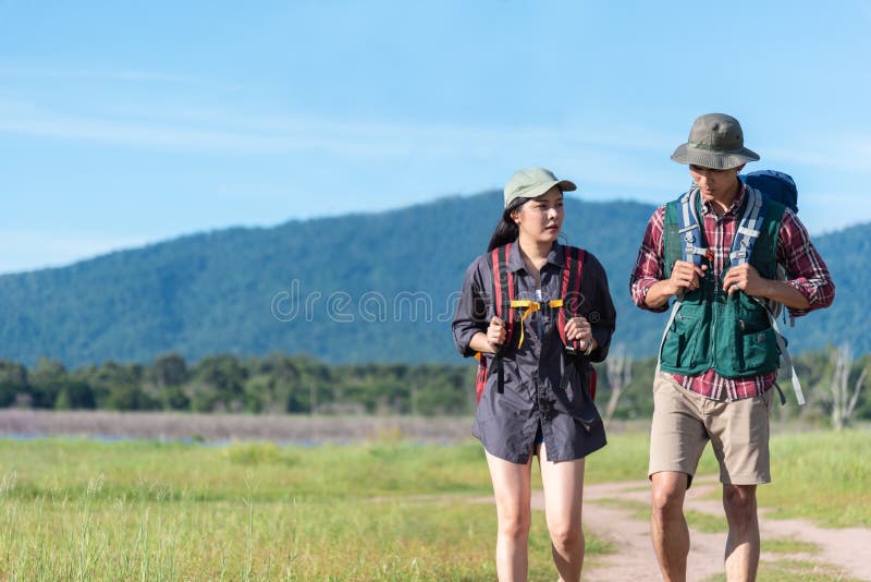 Twee mensen die op weg op weidegebied lopen Mannelijke en vrouwelijke reiziger die het punt van de aantrekkelijkheidsmening bekij royalty-vrije stock foto's Twee mensen die op weg op weidegebied lopen Mannelijke en vrouwelijke reiziger die het punt van de aantrekkelijkheidsmening bekij royalty-vrije stock foto's