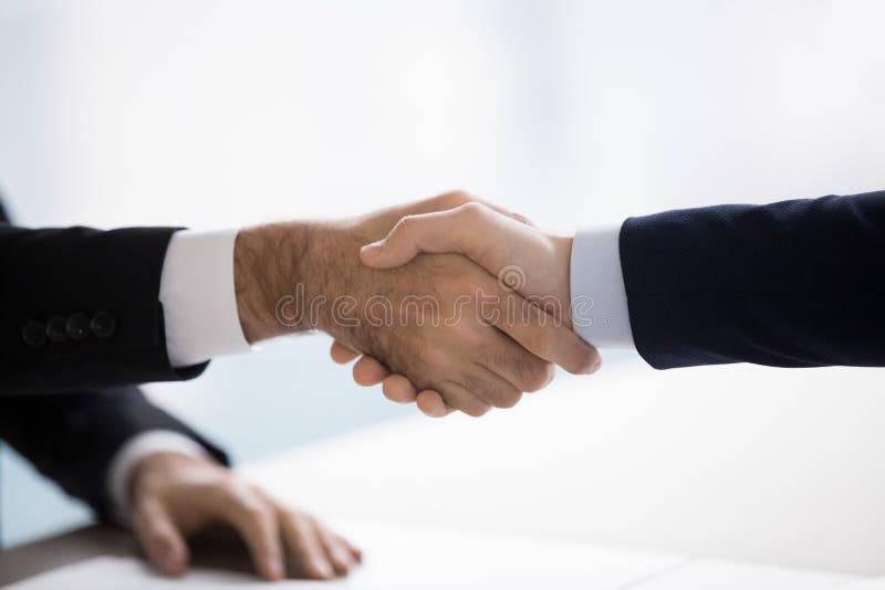 Twee mannen in pakken schudden elkaar de hand. Close-up, concept stock afbeeldingen