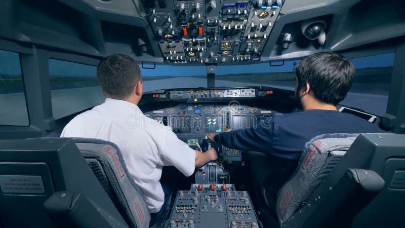Twee mensen zitten in een cockpit van een vluchtsimulator De vluchtdek van de cockpitcabine