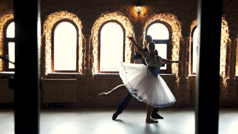 Twee moderne balletdansers die in studio praktizeren