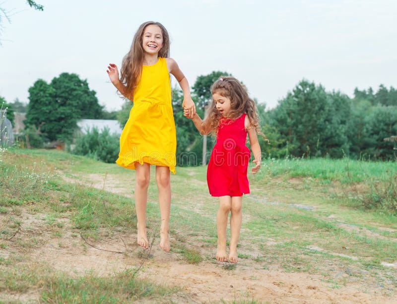 Twee mooie meisjes springt bij zonnige de zomerdag hap royalty-vrije stock afbeelding Twee mooie meisjes springt bij zonnige de zomerdag hap royalty-vrije stock afbeelding