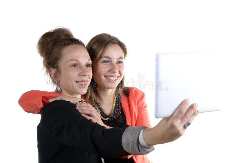 Twee mooie tienermeisjes die selfies met haar digitale tablet nemen stock afbeelding Twee mooie tienermeisjes die selfies met haar digitale tablet nemen stock afbeelding
