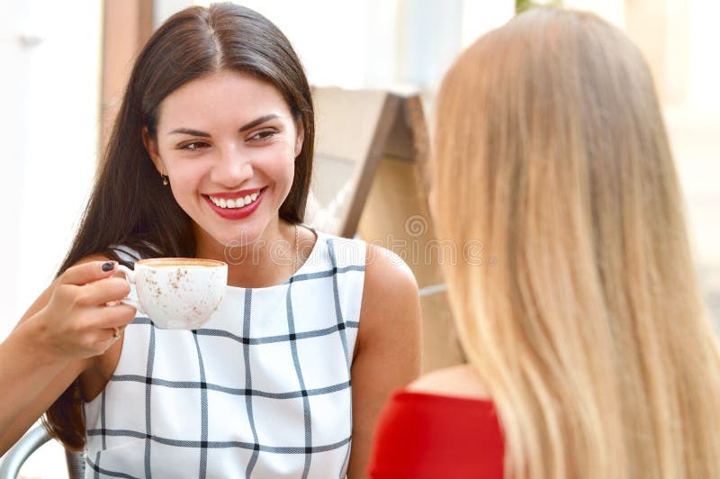 Twee mooie vrouwen die koffie drinken bij buitenkantbar royalty-vrije stock afbeeldingen Twee mooie vrouwen die koffie drinken bij buitenkantbar royalty-vrije stock afbeeldingen