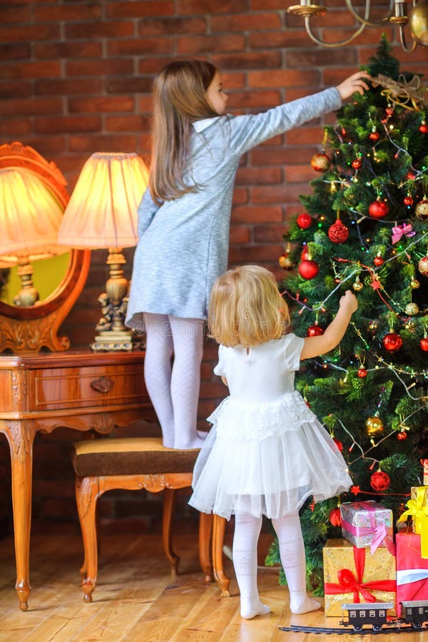 Twee mooie zusters verfraaien de Kerstboom