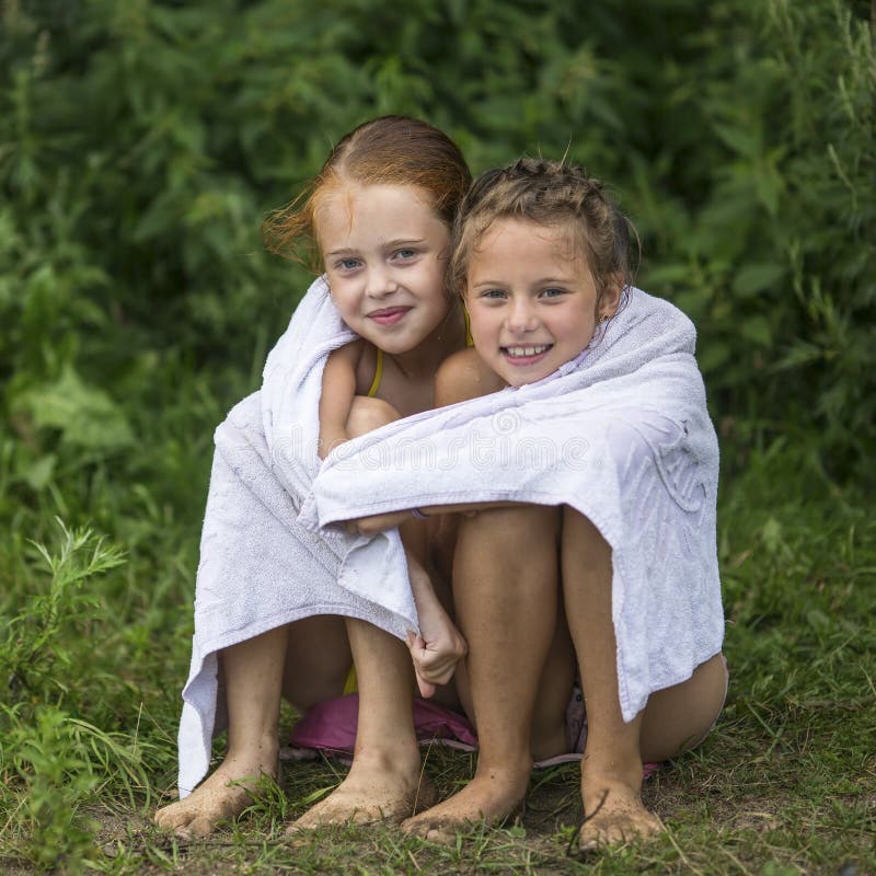 Twee Ongehoorzame Meisjes Die Op Het Strand In Een Handdoek Na Zitten ... picture