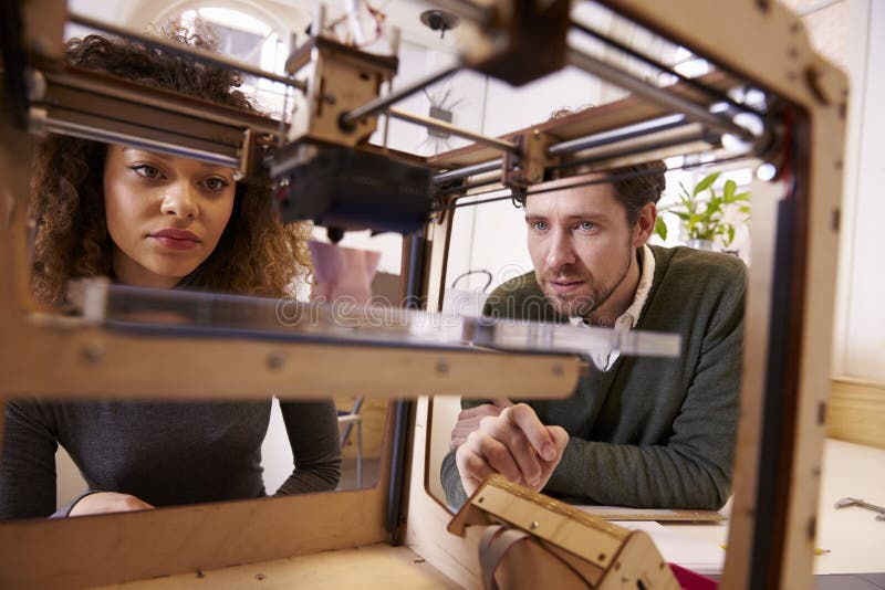 Two Designers Working With 3D Printer In Design Studio. Two Designers Working With 3D Printer In Design Studio