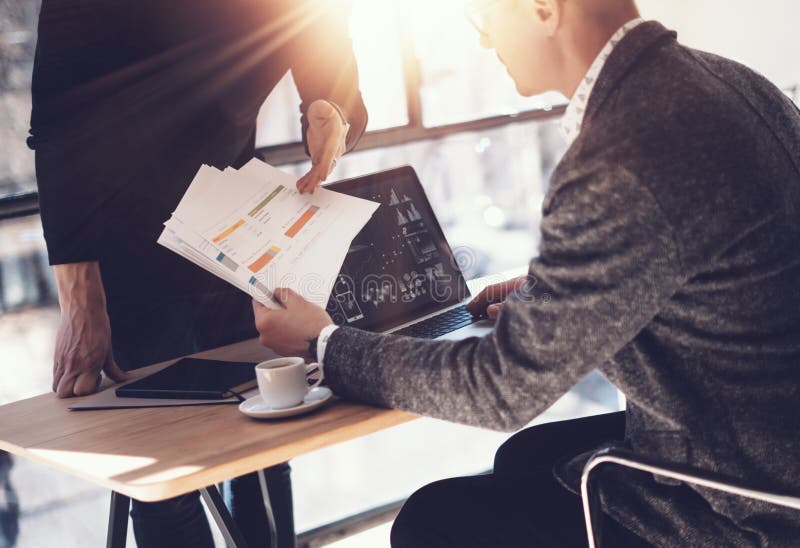 Twee partners die onderzoek voor nieuwe bedrijfsrichting maken Volwassen zakenman die moderne laptop werken en documenten tonen a stock foto Twee partners die onderzoek voor nieuwe bedrijfsrichting maken Volwassen zakenman die moderne laptop werken en documenten tonen a stock foto