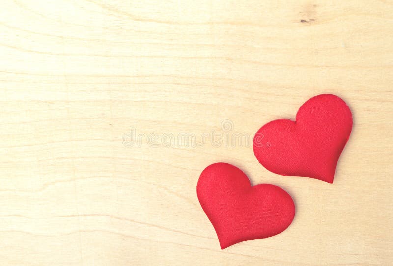 Twee rode harten op een houten raad