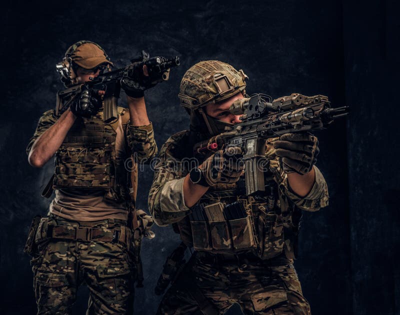 Twee speciale krachtenmilitairen in volledige beschermingsmiddelholding vallen geweren en het streven naar de doelstellingen aan royalty-vrije stock fotografie Twee speciale krachtenmilitairen in volledige beschermingsmiddelholding vallen geweren en het streven naar de doelstellingen aan royalty-vrije stock fotografie