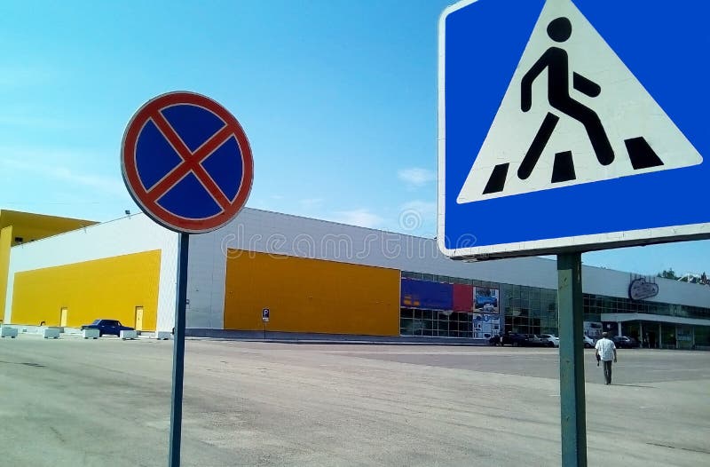 Twee verkeersteken op een achtergrond van een winkelcentrum en een blauwe hemel royalty-vrije stock afbeelding Twee verkeersteken op een achtergrond van een winkelcentrum en een blauwe hemel royalty-vrije stock afbeelding