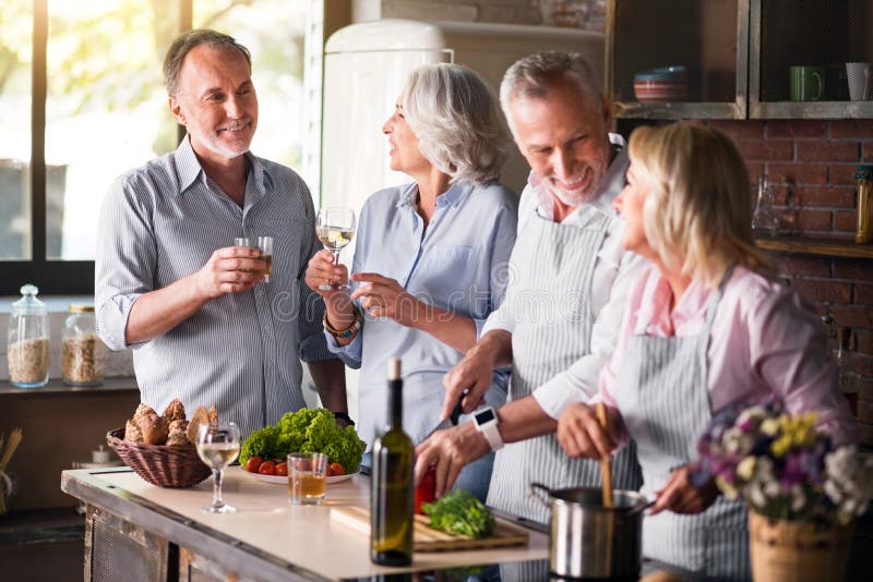 Twee verouderde families die voor lunch bijeenkomen stock afbeelding Twee verouderde families die voor lunch bijeenkomen stock afbeelding