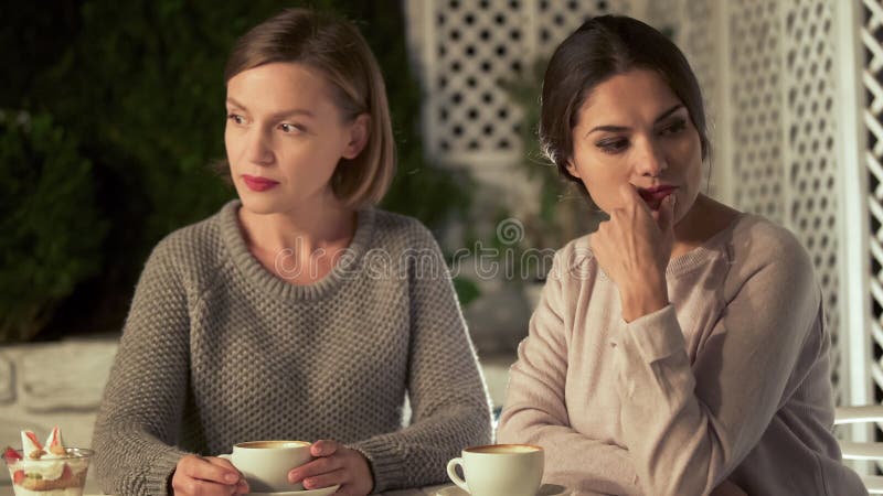 Twee verstoorde vrouwelijke vrienden die in koffie, relatiesconflict, misverstand zitten stock fotografie Twee verstoorde vrouwelijke vrienden die in koffie, relatiesconflict, misverstand zitten stock fotografie