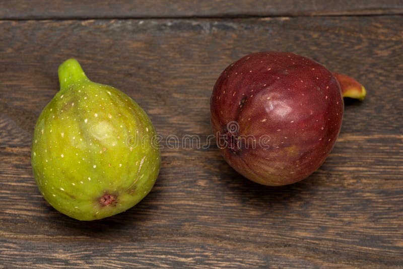 Red purple and green fig fruit on a dark brown table. Red purple and green fig fruit on a dark brown table