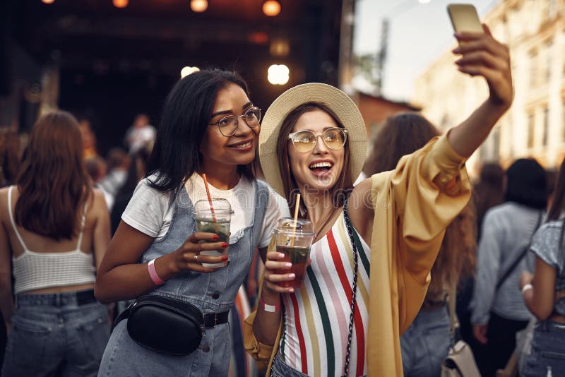 Twee vrolijke meisjes die met cocktails selfie maken royalty-vrije stock foto's Twee vrolijke meisjes die met cocktails selfie maken royalty-vrije stock foto's