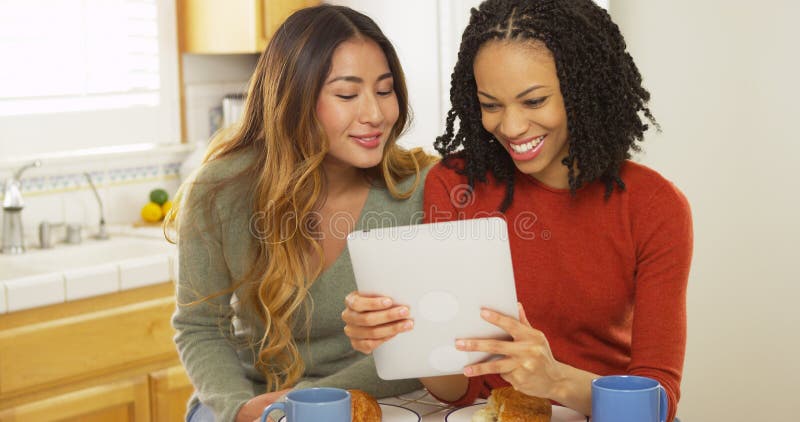 Twee vrouwen beste vrienden die ontbijt eten en tabletcomputer met behulp van stock fotografie Twee vrouwen beste vrienden die ontbijt eten en tabletcomputer met behulp van stock fotografie