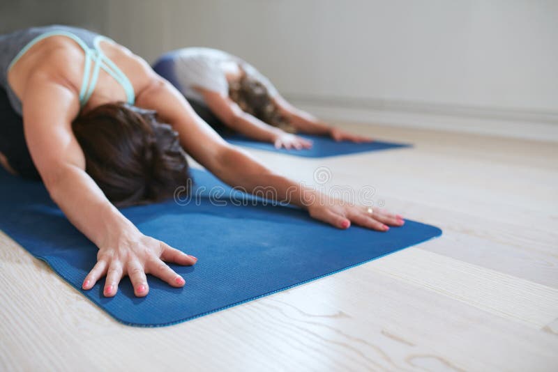 Twee vrouwen die in kind ontspannen stellen het doen van yoga royalty-vrije stock foto's Twee vrouwen die in kind ontspannen stellen het doen van yoga royalty-vrije stock foto's