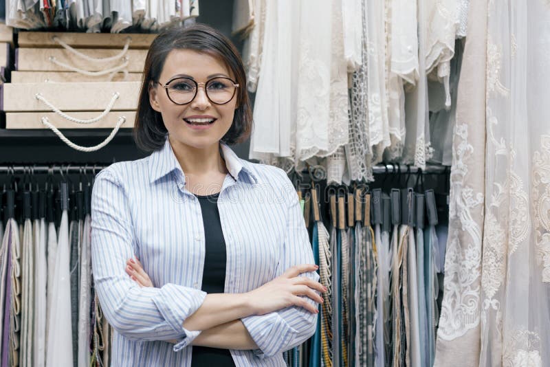 Twee vrouwen die met stoffen voor gordijnen, stoffering, wijfjes werken kiezen stoffen gebruikend computer Werkplaatsontwerper, v stock foto Twee vrouwen die met stoffen voor gordijnen, stoffering, wijfjes werken kiezen stoffen gebruikend computer Werkplaatsontwerper, v stock foto