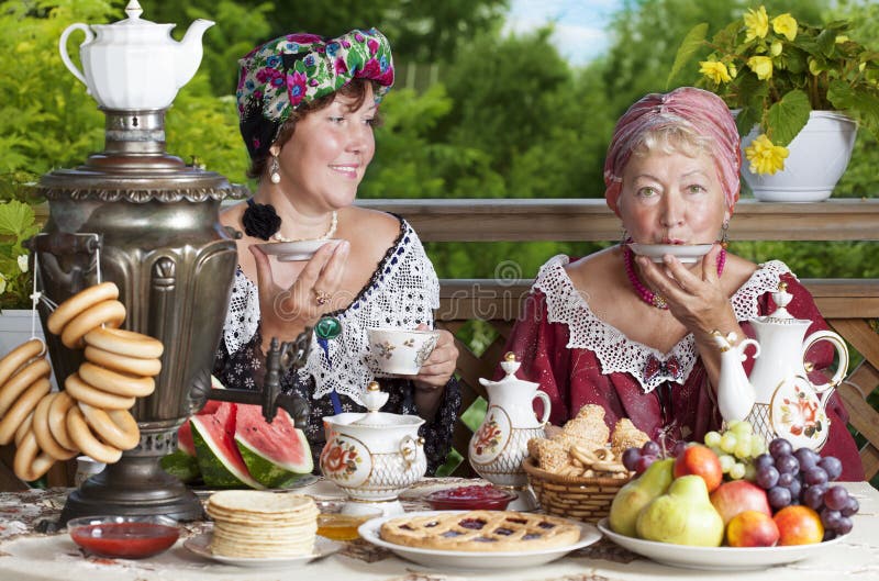 Twee vrouwen die van een kop thee genieten stock afbeeldingen Twee vrouwen die van een kop thee genieten stock afbeeldingen