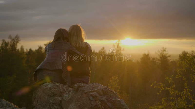 Twee vrouwen kijken op de zonsondergang