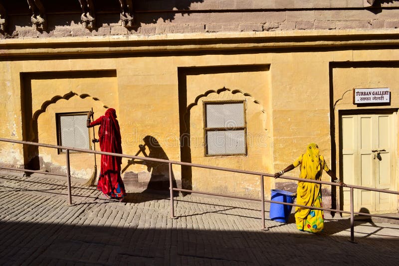 Twee vrouwen in traditionele Indische doek die de binnenplaats vegen stock fotografie Twee vrouwen in traditionele Indische doek die de binnenplaats vegen stock fotografie