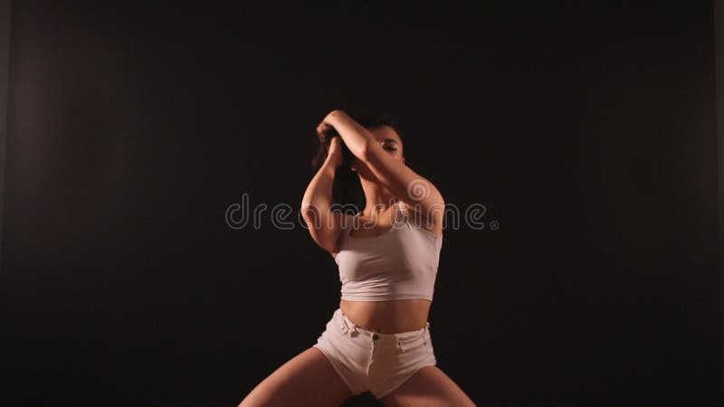 Twerk добычи женщины танцуя сидя на поле на голубой предпосылке сток-видео
