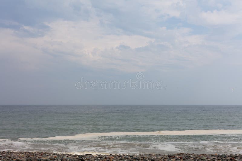 Twilight in the beautiful nature horizon image with blue sky. Ocean waves on the beach with blue sky with clouds on the horizon. R stock photography Twilight in the beautiful nature horizon image with blue sky. Ocean waves on the beach with blue sky with clouds on the horizon. R stock photography