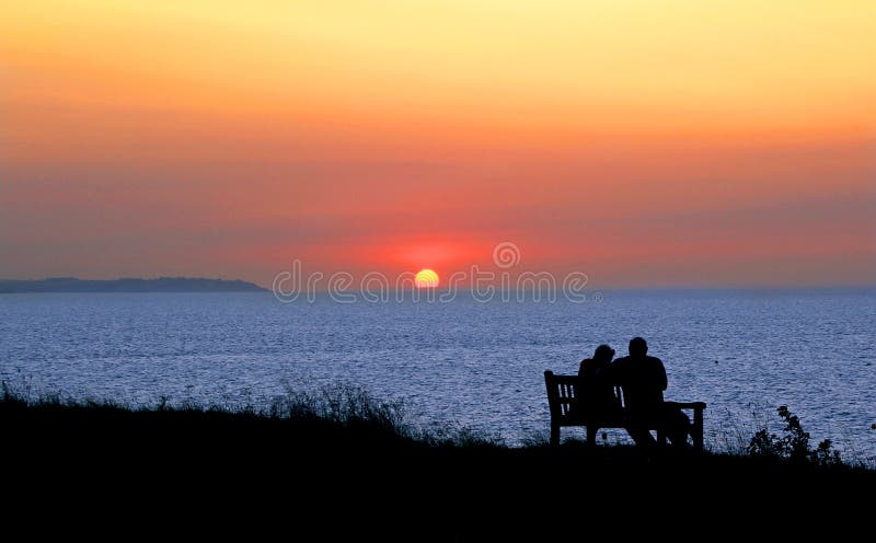 Foto di un staglia romantico in coppia sulla panchina a guardare un bel kent tramonto.