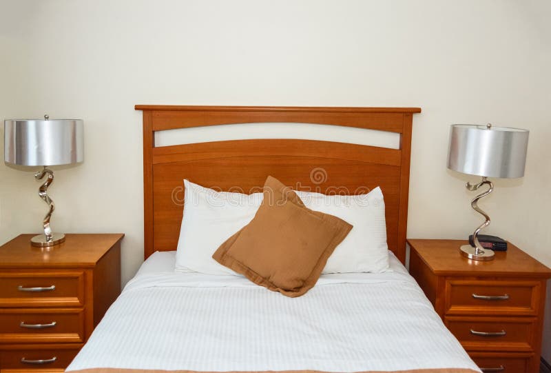 Twin Bed in the Bedroom with the Lamp on Bedside Tables Stock Photo