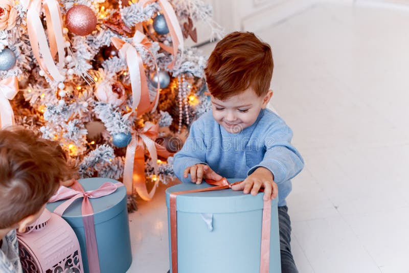 Twin brothers in front of the christmas tree with candles and gifts. love, happiness and big family concept royalty free stock image Twin brothers in front of the christmas tree with candles and gifts. love, happiness and big family concept royalty free stock image