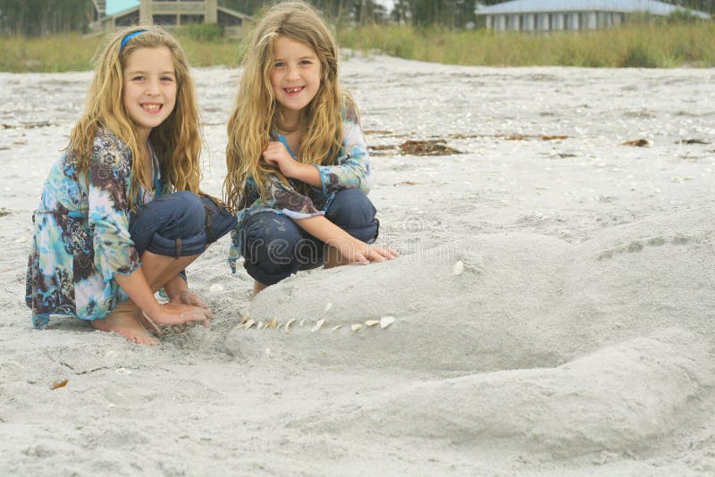 Twins with alligator sand castle