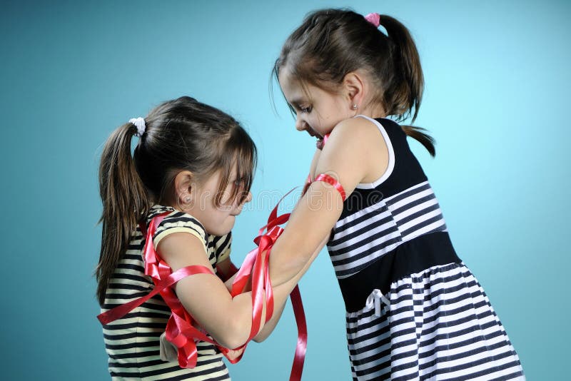 Twins exercising with red accessory