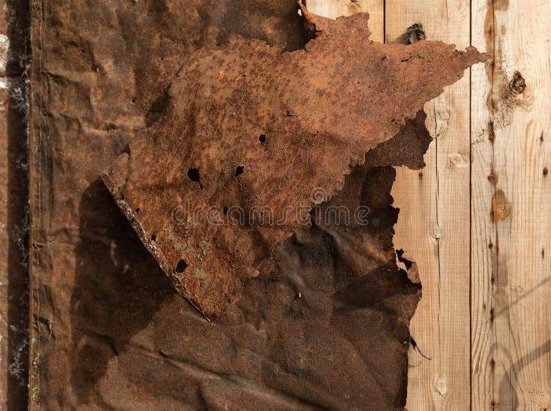 Rusty Twisted Sheet Metal on Wooden Plank Wall