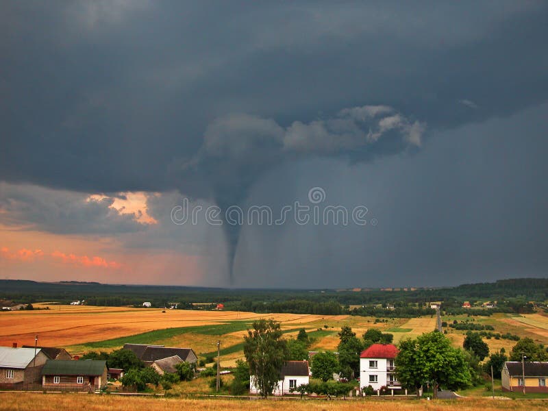 View of the serene countryside and stormy sky with a tornado in the background. View of the serene countryside and stormy sky with a tornado in the background.