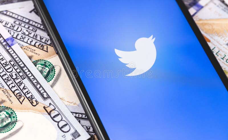 Twitter logo on the screen smartphone and money dollars
