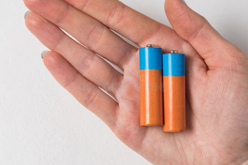 Two AA Alkaline Batteries in Hand on White Background. Closeup Copy