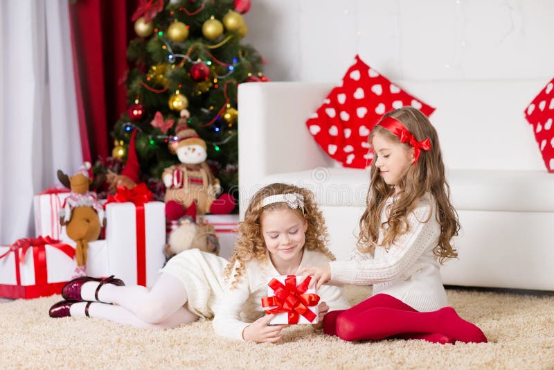 Two adorable curly girls playing with gift box