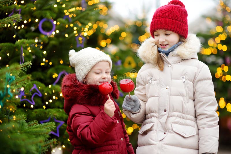 Two Adorable Little Sisters Eating Red Apples Covered with Sugar Icing ...