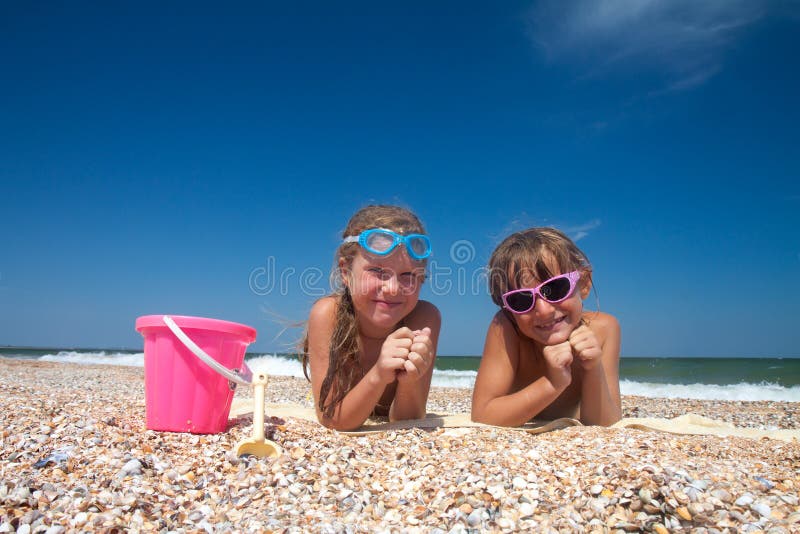 Two adorable toddler girl on sand beach