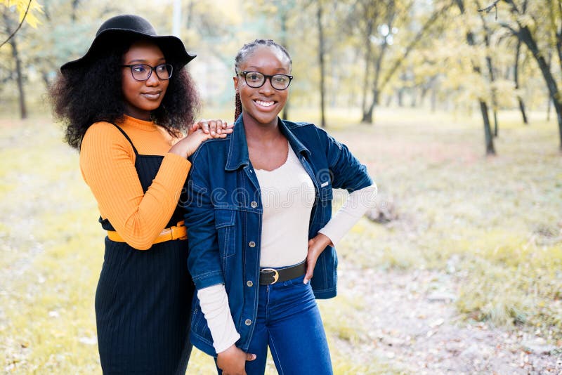 two african american sisters women having fun in the park outdoors