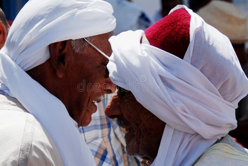 Two Arab Gentlemen, Douz Market, Tunisia. Two elderly Arab Gentlemen in traditional costumes and headwear chatting in Douz Market, Douz, Tunisia stock image Two Arab Gentlemen, Douz Market, Tunisia. Two elderly Arab Gentlemen in traditional costumes and headwear chatting in Douz Market, Douz, Tunisia stock image