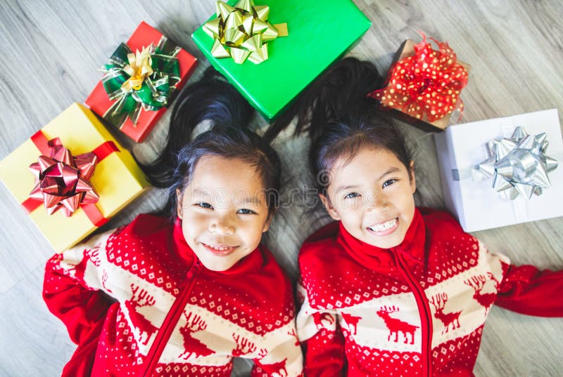 Two asian child girls laying down on the floor and play together in Christmas celebration stock photos Two asian child girls laying down on the floor and play together in Christmas celebration stock photos