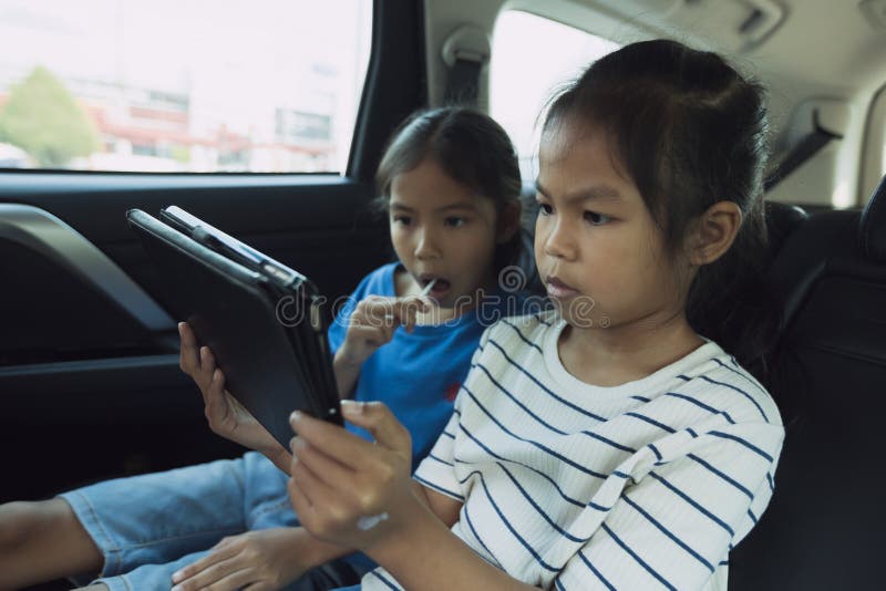 https://thumbs.dreamstime.com/b/two-asian-child-girls-sitting-backseat-watching-cartoon-tablet-together-traveling-car-fun-childhood-216003840.jpg